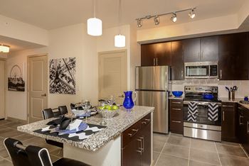 Kitchen Island with Pendant Lighting & USB Outlets at Azura Luxury Apartments in Kendall, FL